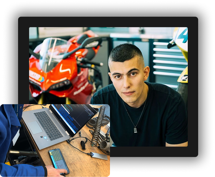 Young engineer working on motorcycle diagnostics in a workshop.
